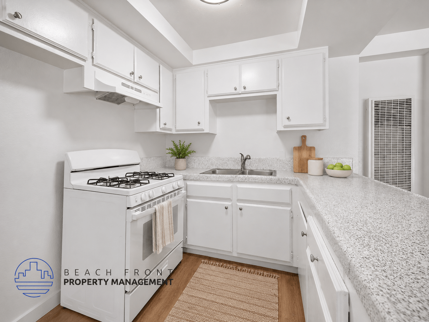 A kitchen with white cabinets and a white stove top oven.